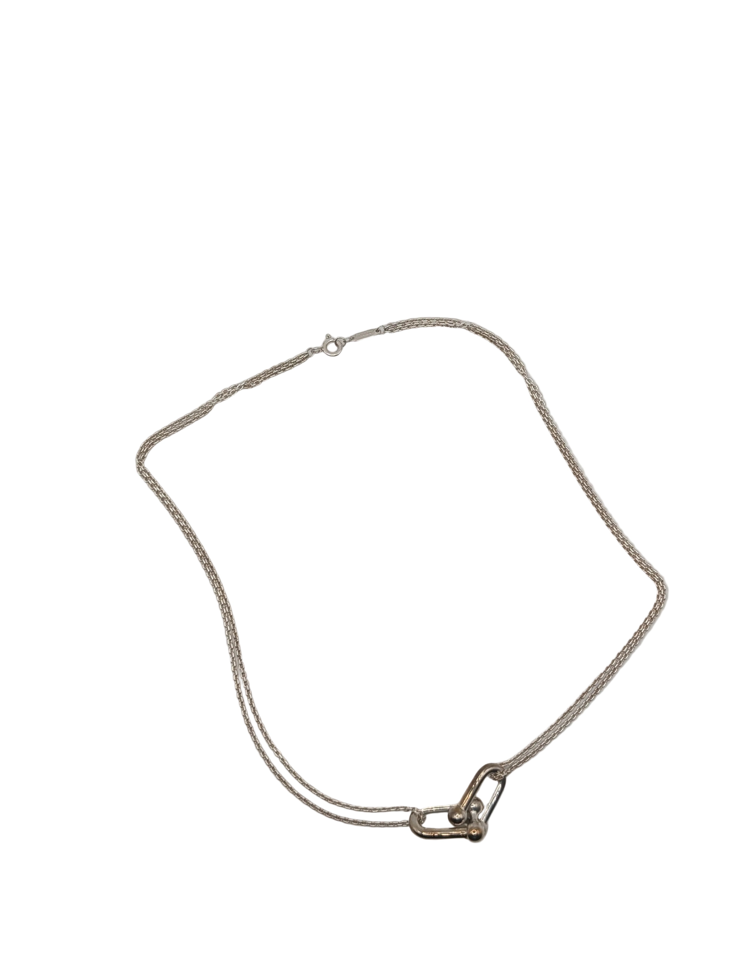 Silver necklace with a clasp on a light gray background