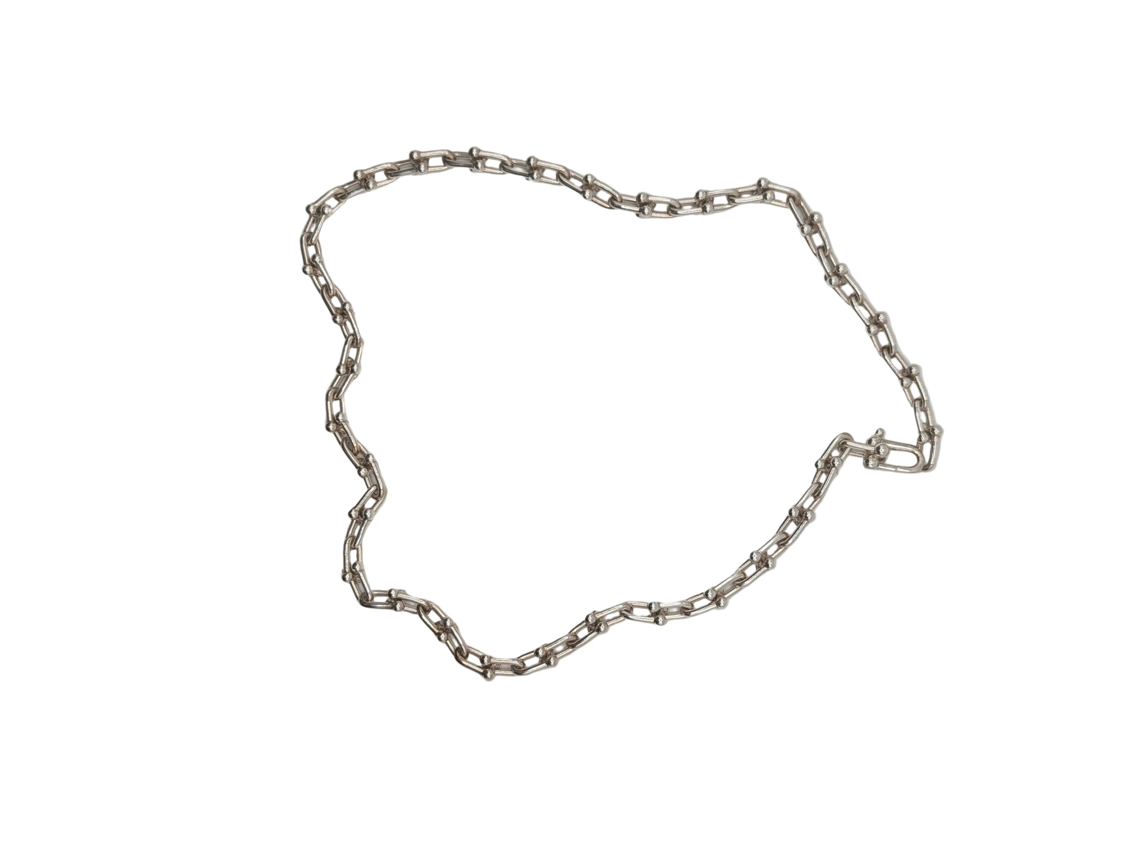 Silver chain necklace on a light gray background