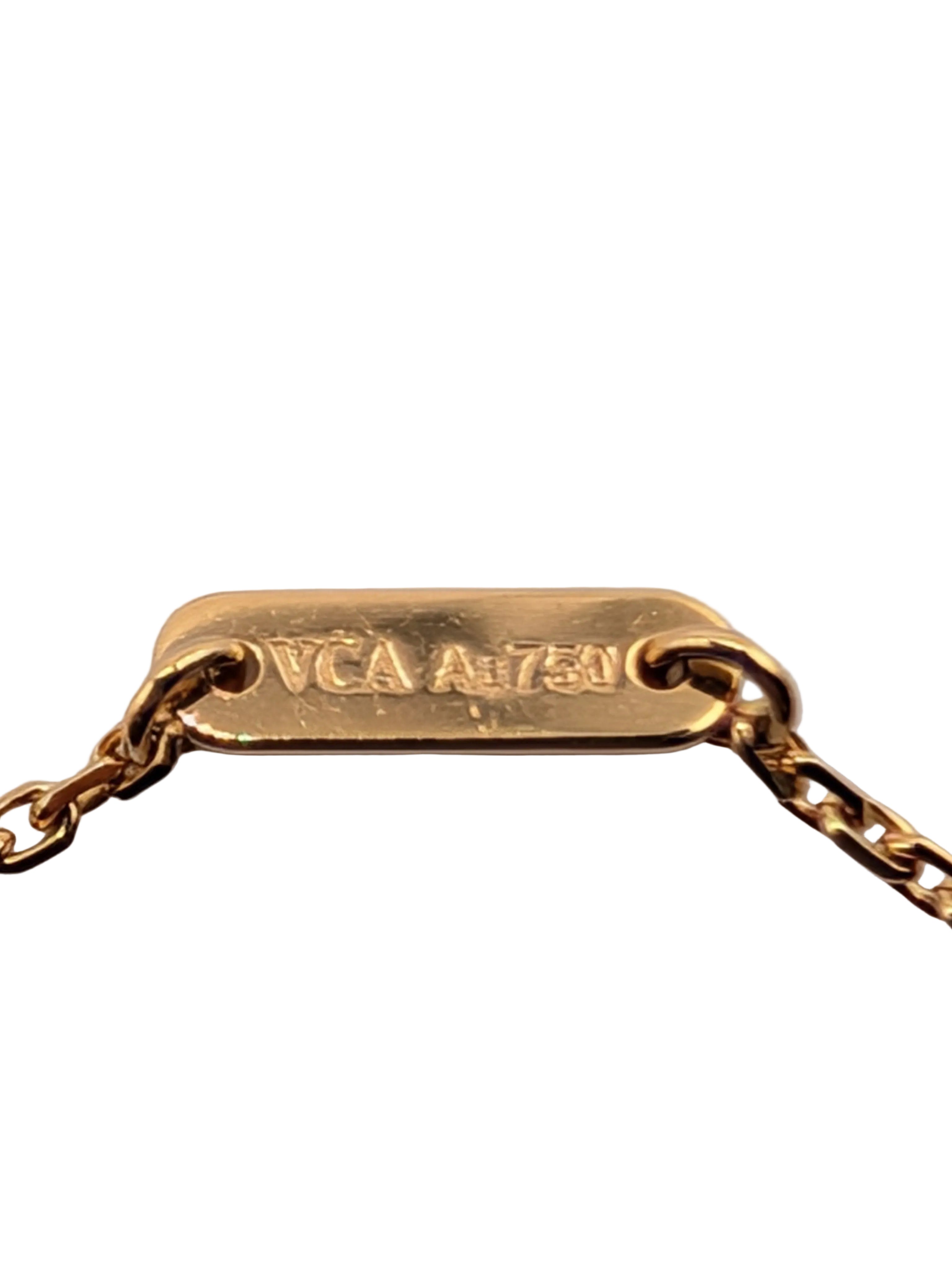 A close-up of a gold chain necklace with a rectangular gold tag engraved with 'VCA A 1750' on a light gray background.